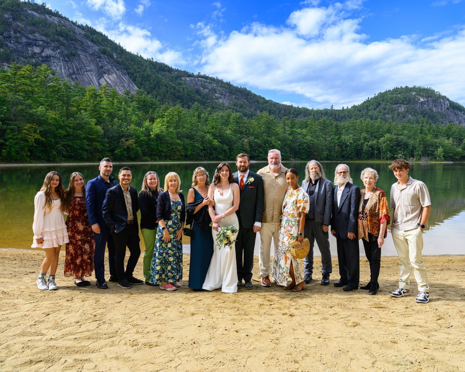 Wedding guests gathered on the Echo Lake State Park beach with the granite ledges of North Conway behind them
