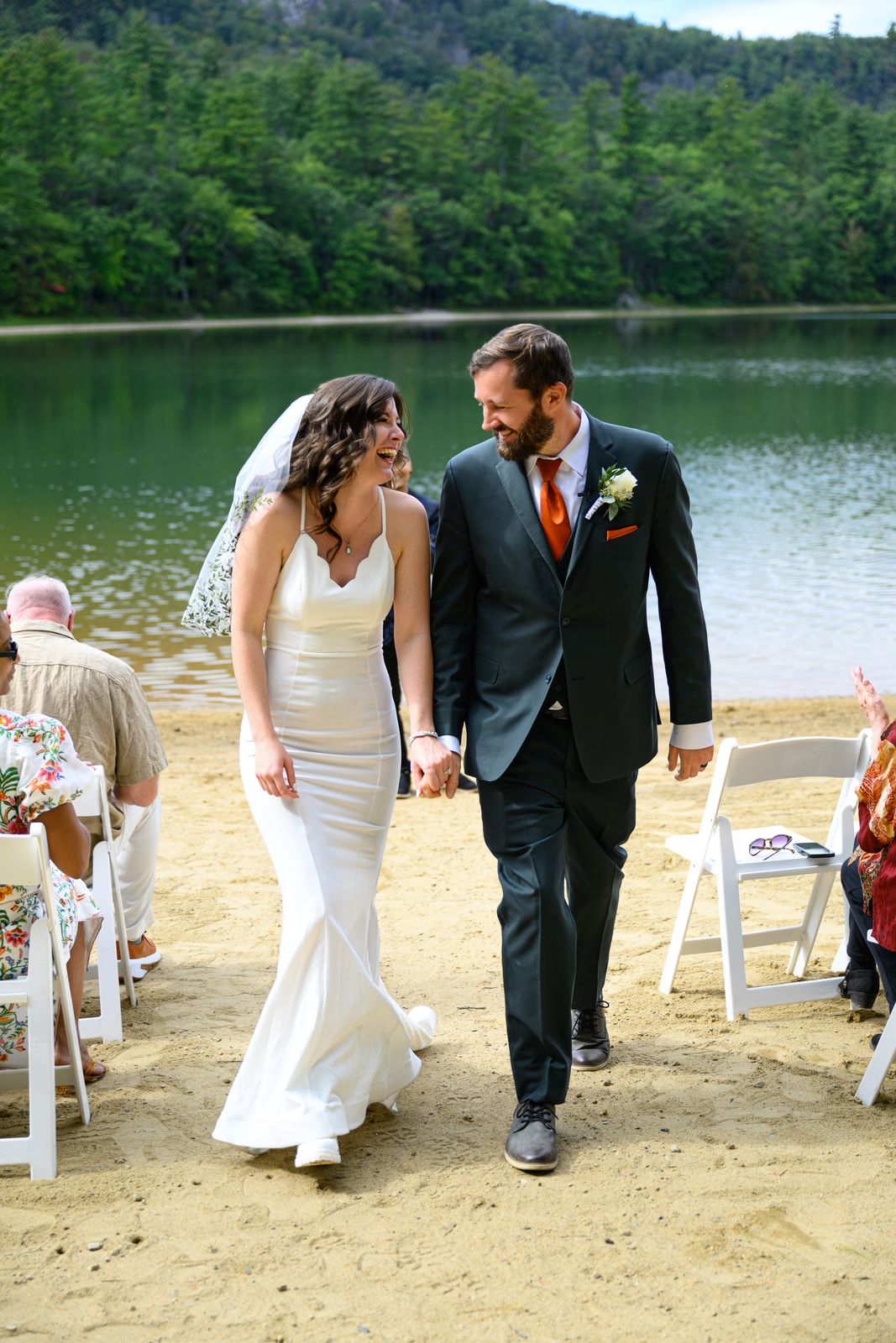 Newlyweds walking up the aisle between guests on the Echo Lake beach