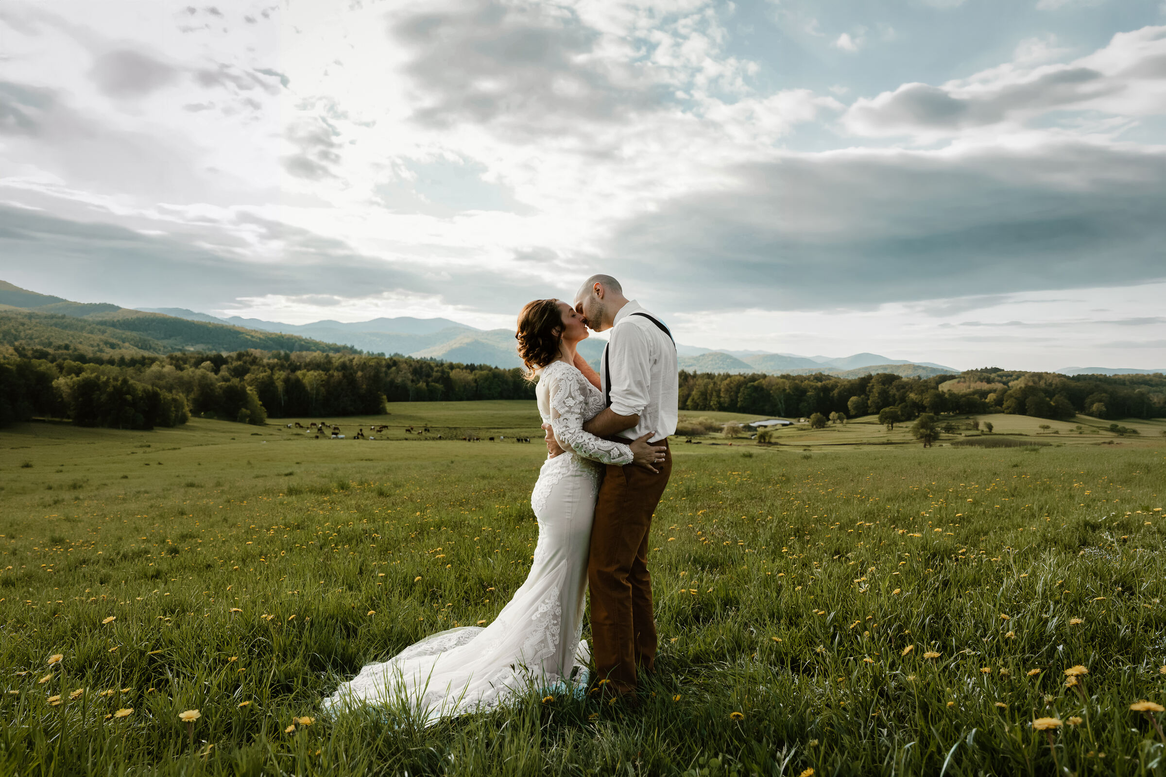 Couple embracing in a mountain meadow during their New Hampshire elopement