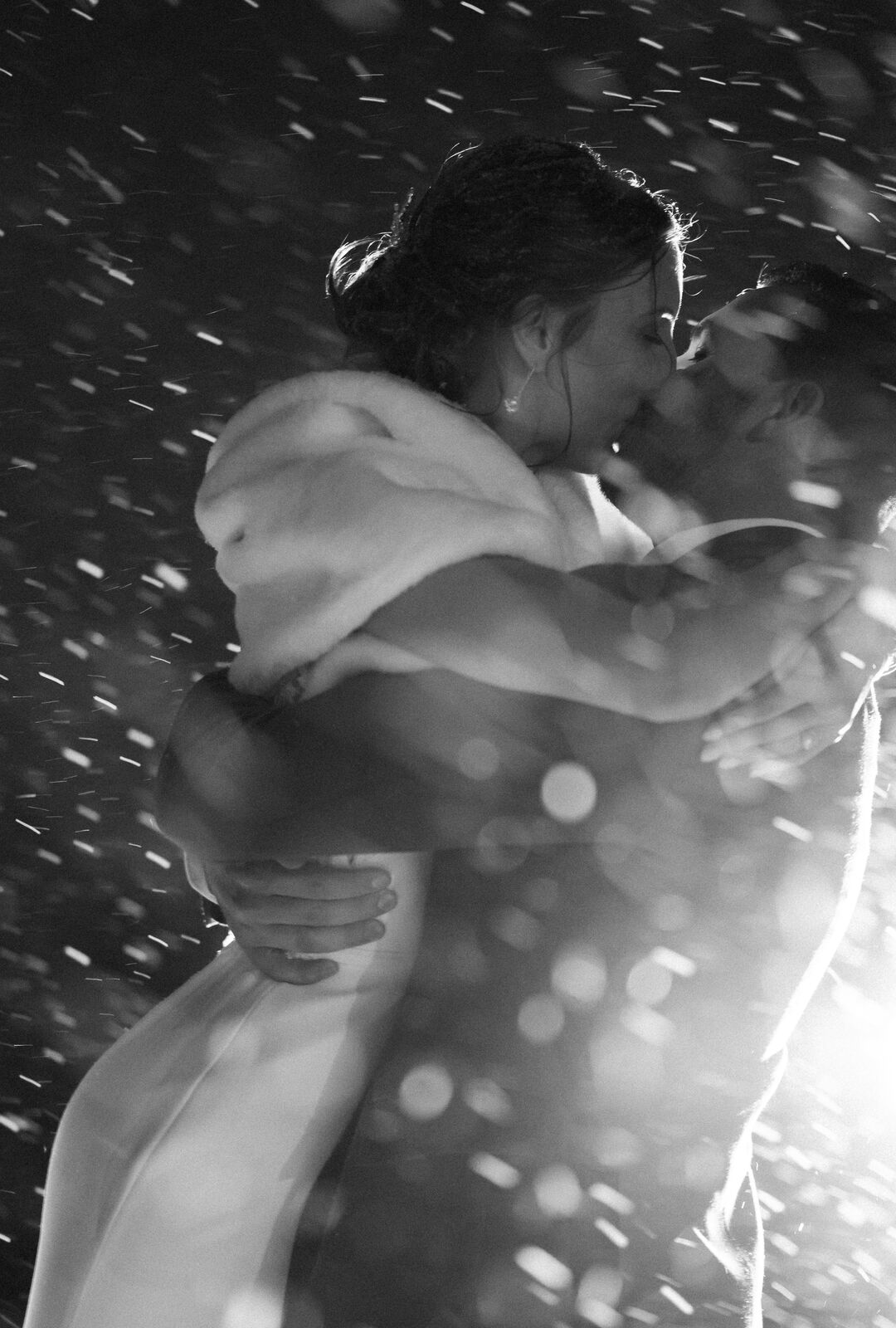 Couple embracing in the rain, black and white